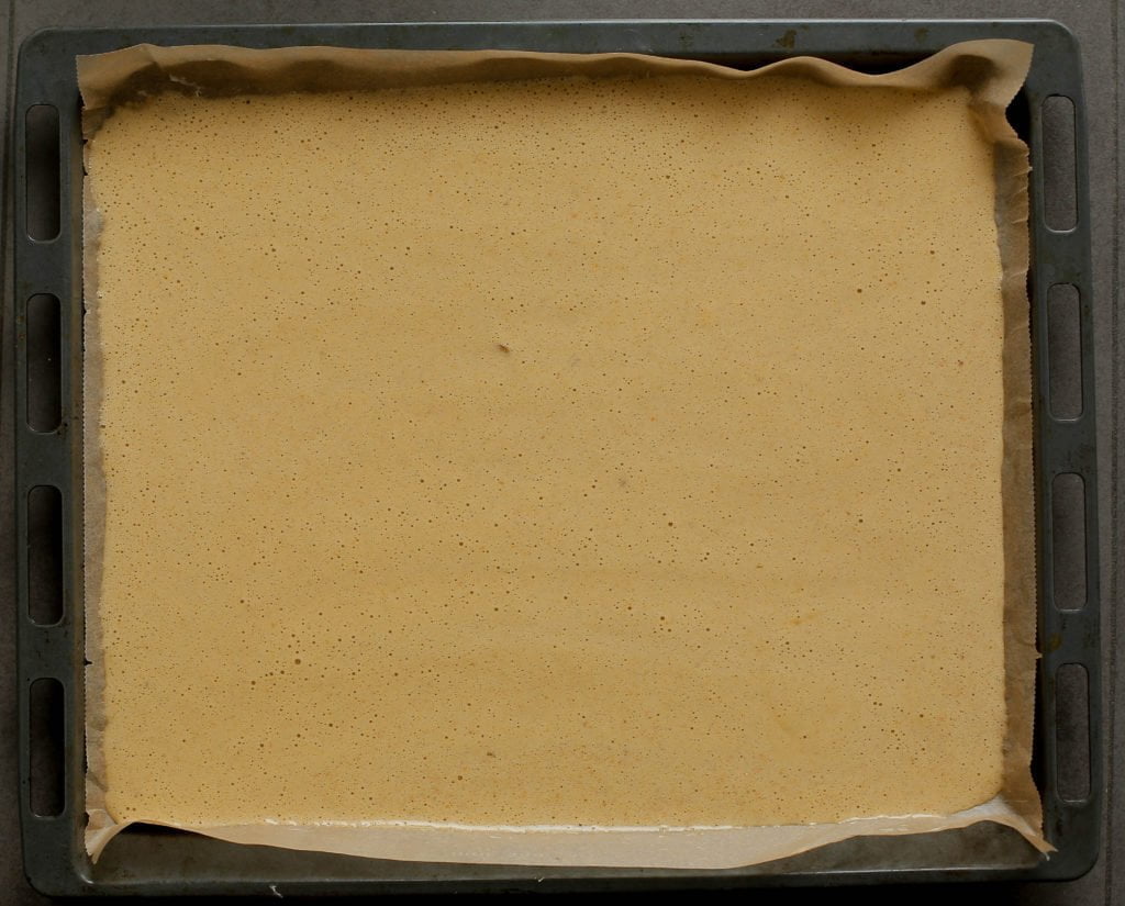 Vet de bakpapier beklede bakplaat goed in en voeg het beslag toe. Smeer het wortelbeslag netjes en gelijkmatig uit. Leg de wortelcake in een voorverwarmde oven op 200℃. Bak de wortelcake in ca. 8-10 minuten gaar.