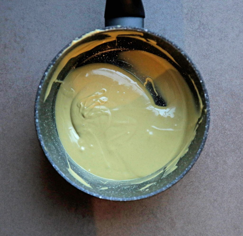 Doe de pistachespread in een steelpan. Warm deze op laag vuur tot het vloeibaar is. Blijf erbij staan om te roeren, want dit gaat heel snel.