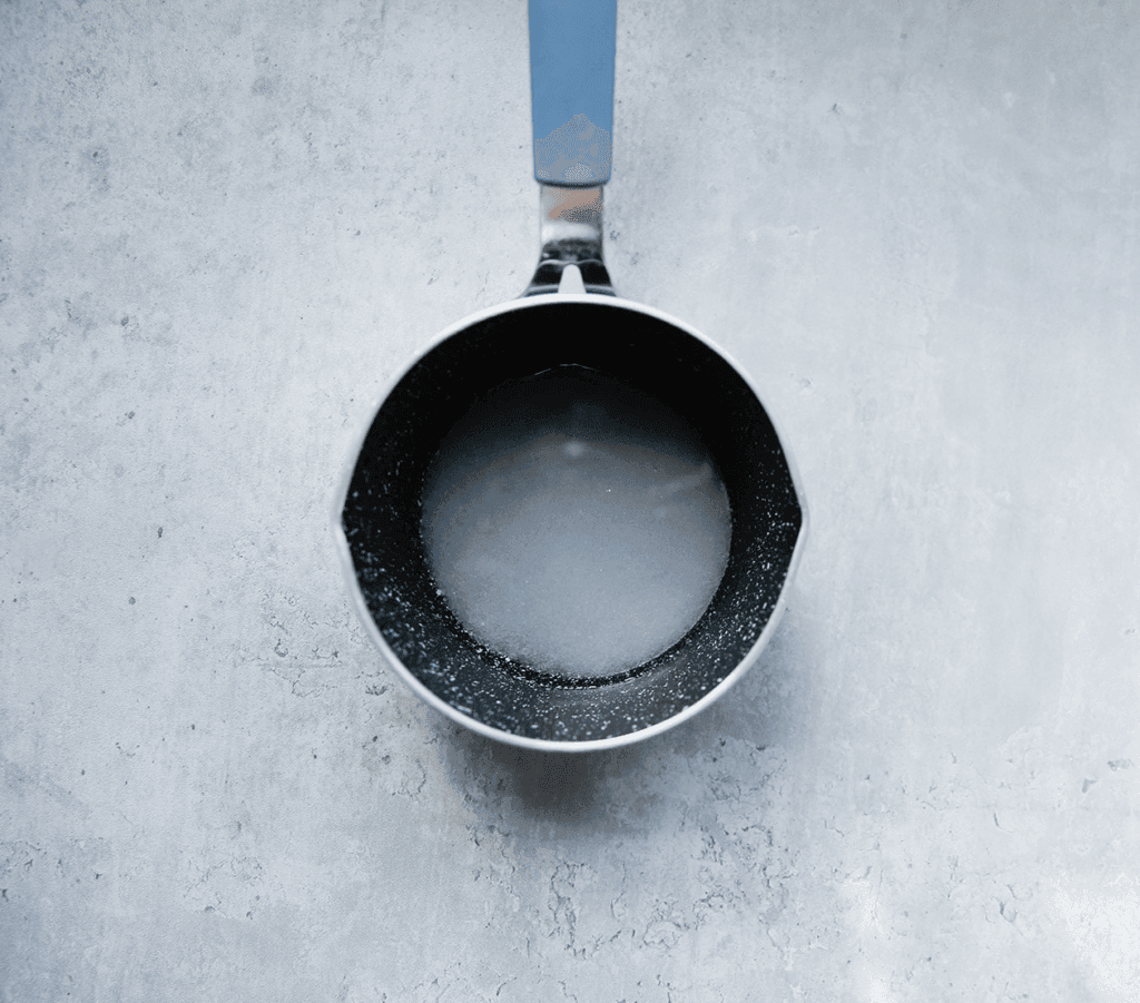 Kook de azijn samen met de suiker in een steelpan. Wanneer de suiker is opgelost, zet je het vuur uit. Laat de siroop op kamertemperatuur komen.