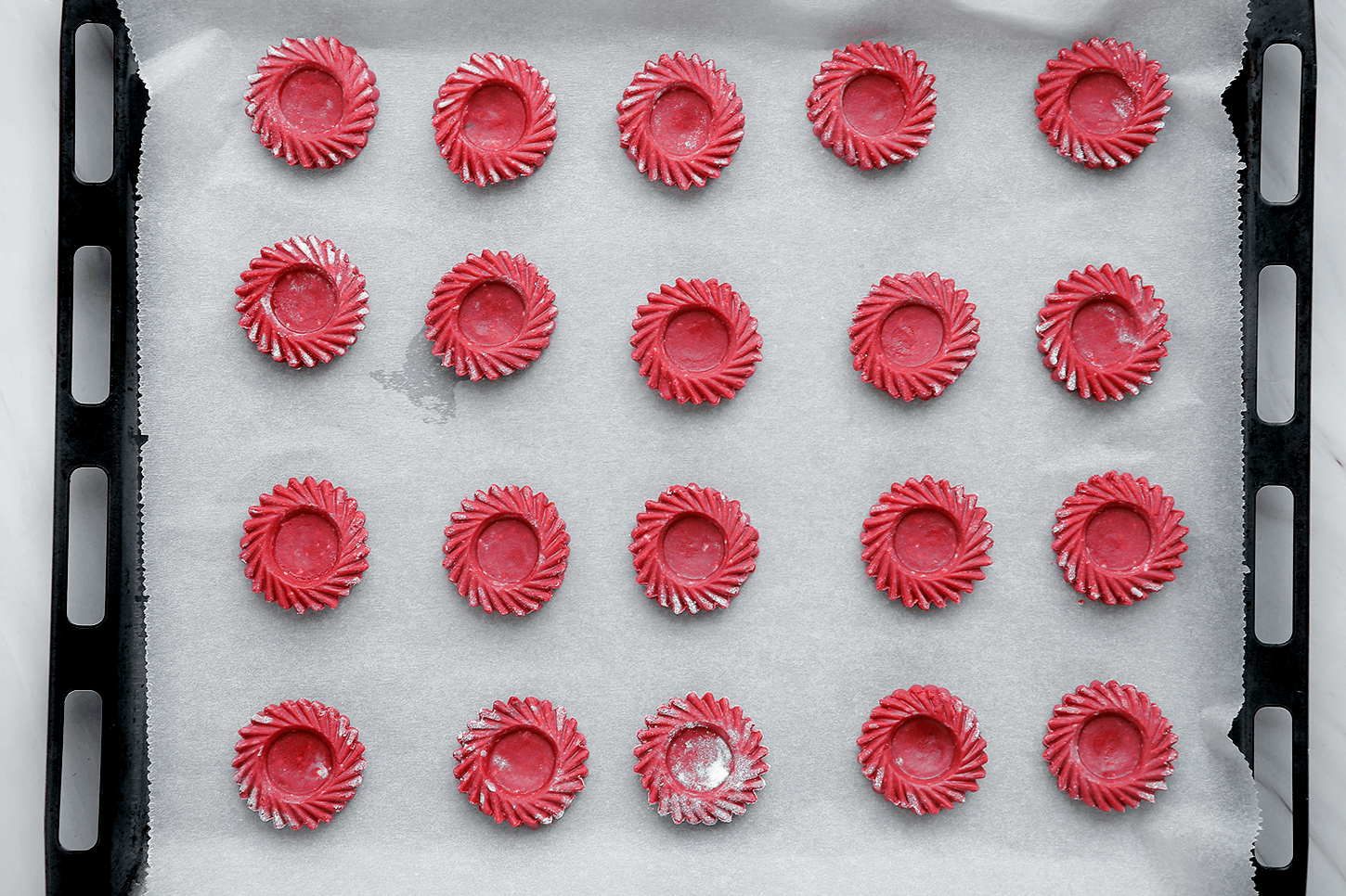 Red velvet koekjes op een bakplaat met bakpapier