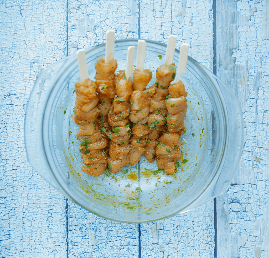 Maak de prikkers nat voor gebruik. Neem een glas en vul met water. Doe de prikkers erin en laat 20 minuten wellen. Rijg de kip aan de spiesjes.