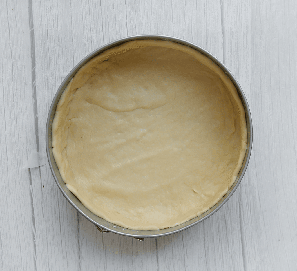 Vul de springvorm met het deeg en druk de zijkanten goed aan.