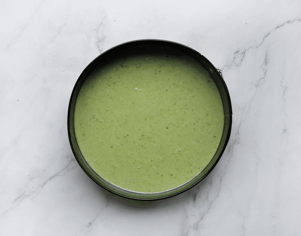 Vet de bakvorm in en leg op de bodem bakpapier neer. Voeg het beslag toe.