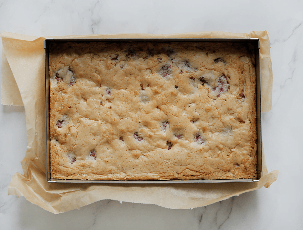 Zet de frambozenblondies in een voorverwarmde oven op 175℃. Bak 25-30 minuten. De cake is gaar wanneer je er met een satéstokje in prikt en er droog uitkomt. Laat compleet afkoelen.