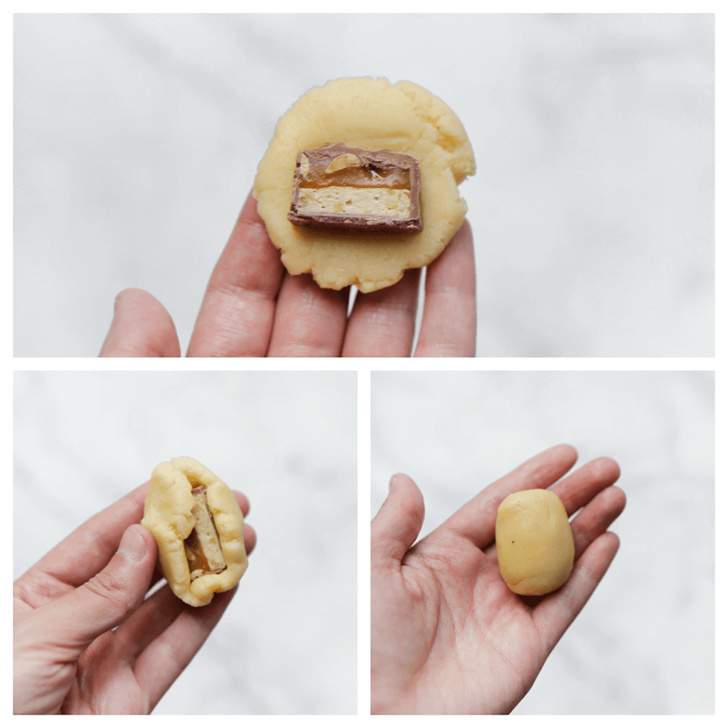 Druk het bolletje plat en leg de Snickers erop. Vouw goed dicht en vorm tot een ovaal.