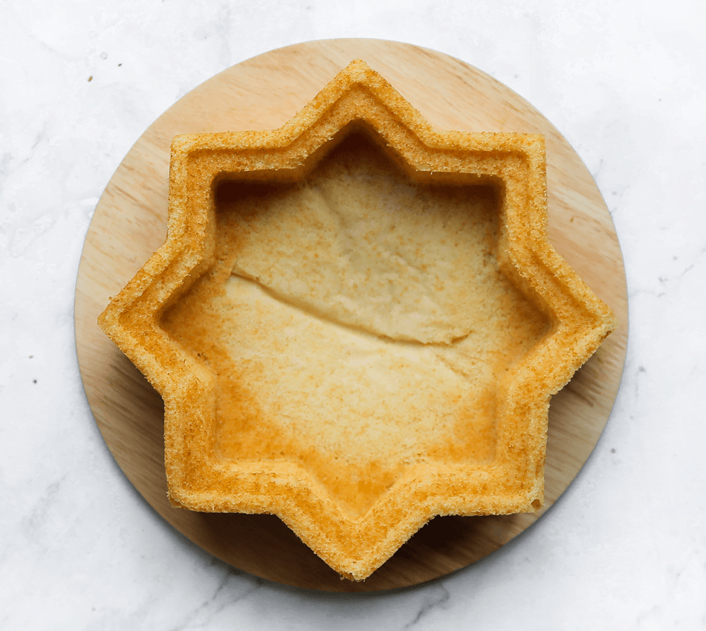 Leg de cake in een voorverwarmde oven op 160 graden. Bak 25-28 minuten of tot de cake gaar is. De cake is gaar als je er met een satéprikker/tandenstoker in prikt en er droog uitkomt. Je ziet dat de randen van de cake meteen loslaten van de bakvorm zodra je de cake uit de oven haalt. Laat de cake 10 minuten afkoelen. Leg er een blad of bord op en kiepel de bakvorm om. Haal de cake uit de bakvorm. Laat de cake afkoelen.