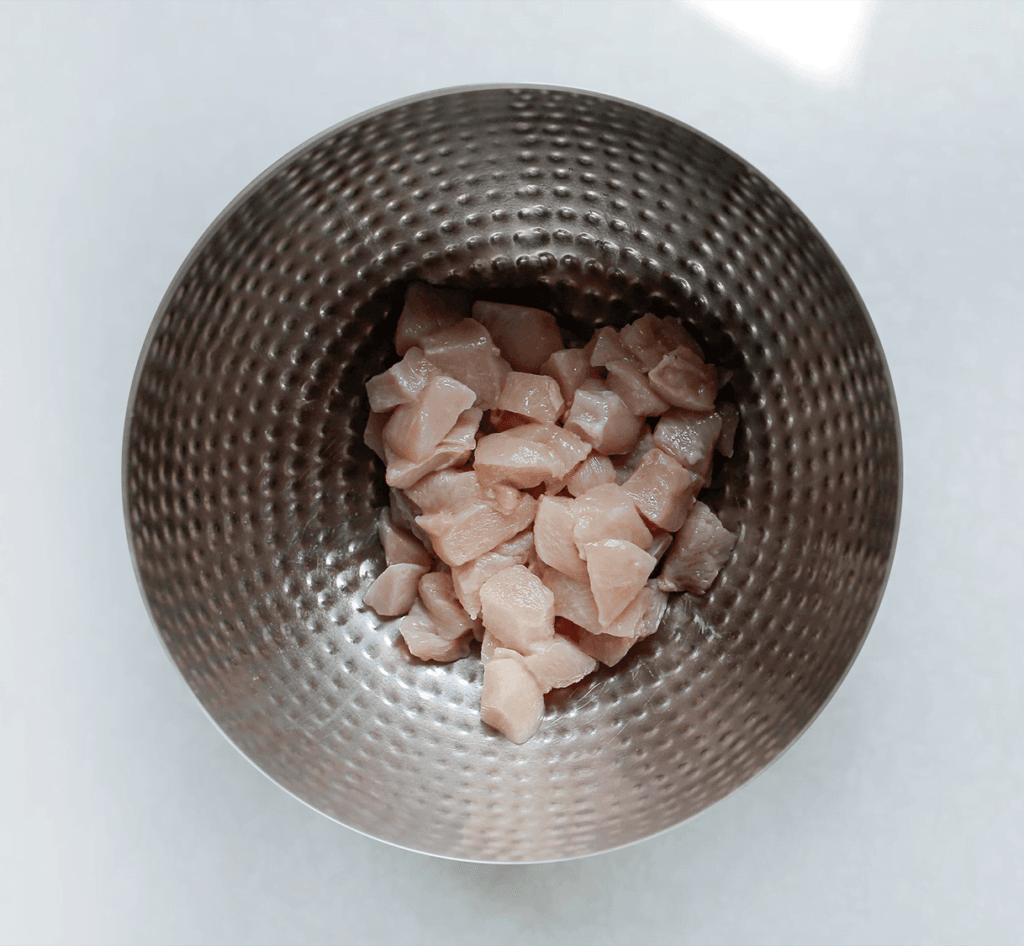 Was en snijd de kipfilet in blokjes.