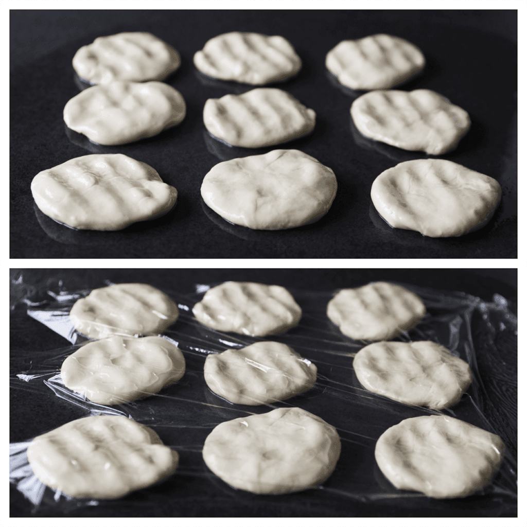 Vet je werkplek in met 20 ml zonnebloemolie. Neem een stuk deeg en haal deze goed door de olie. Herhaal de werkwijze. Druk de bollen plat en bedek met er een vel huishoudfolie. Laat 30-45 minuten staan.