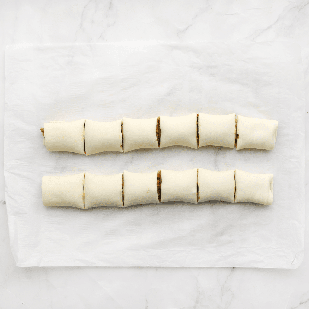 Snijd de gevulde bladerdeeg met kip in stukken.