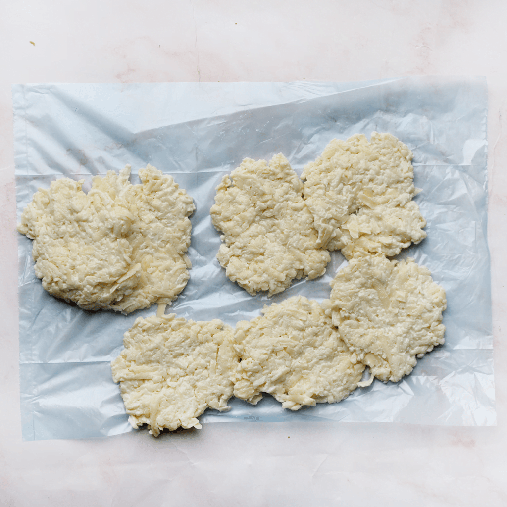 Verdeel het kaasmengsel in 9 stukken en druk ze plat.