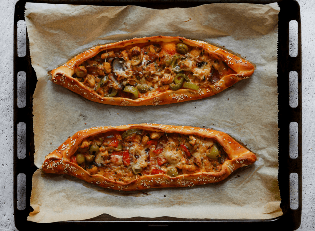 Leg de pide met kip in een voorverwarmde oven op 225 ℃. Bak 12-15 minuten of tot het deeg mooi goudbruin is gekleurd.