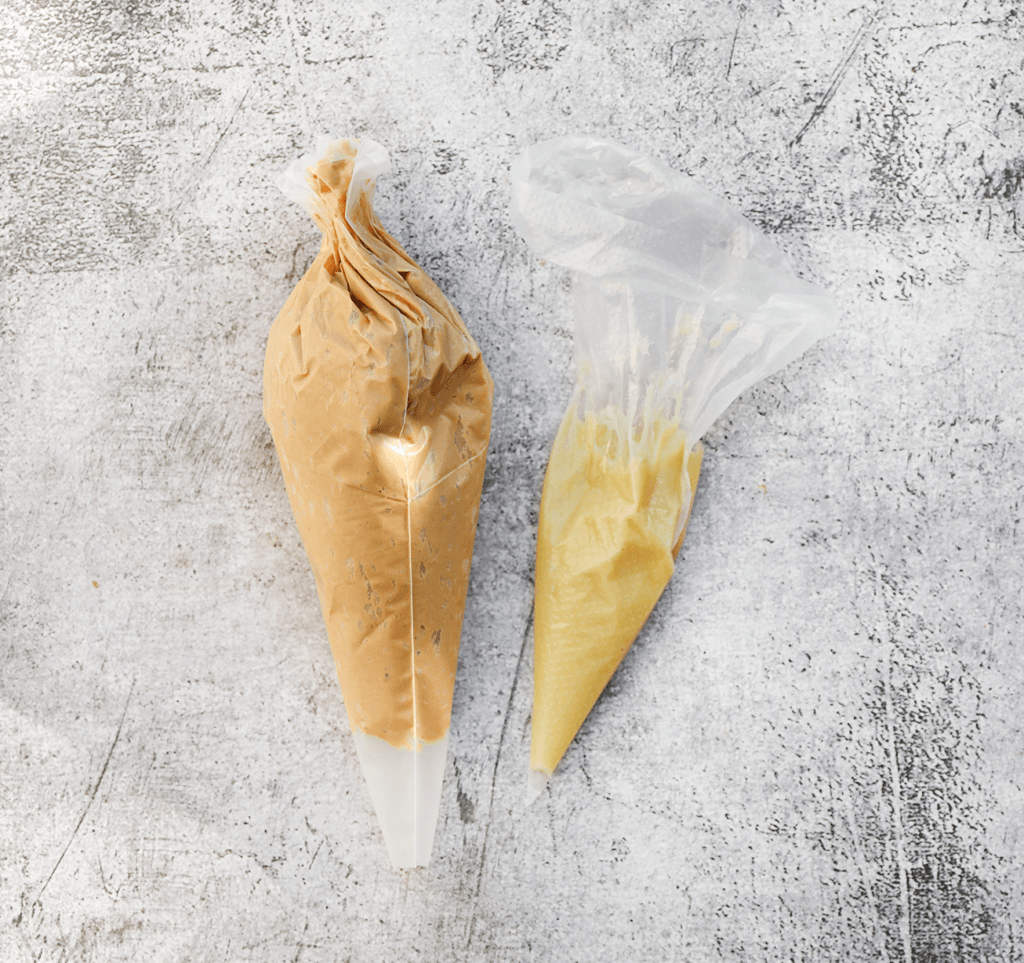 Doe de speculoosroom en witte chocolade in een spuitzak.