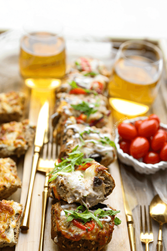 De stokbrood die je over hebt, kun je insmeren met kruidenboter en garneren met lekker veel kaas!