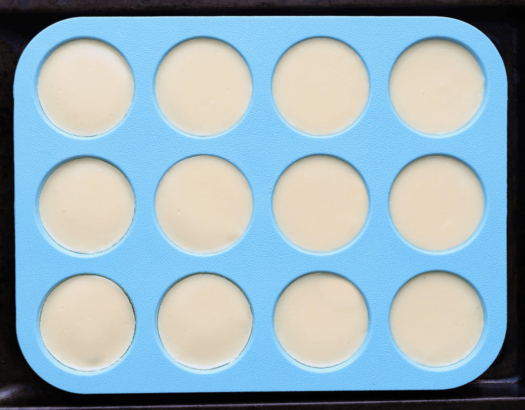 Leg de mini cheesecakes in een voorverwarmde oven op 115 ℃. Bak ze gedurende 22-25 minuten. Schakel de oven uit en laat de mini cheesecakes langzaam afkoelen met de ovendeur dicht, zo voorkom je dat de cheesecakes barsten. Meestal laat ik de cheesecakes 1 uur in de oven, daarna leg ik ze afgedekt in de koelkast (liefst een nachtje).