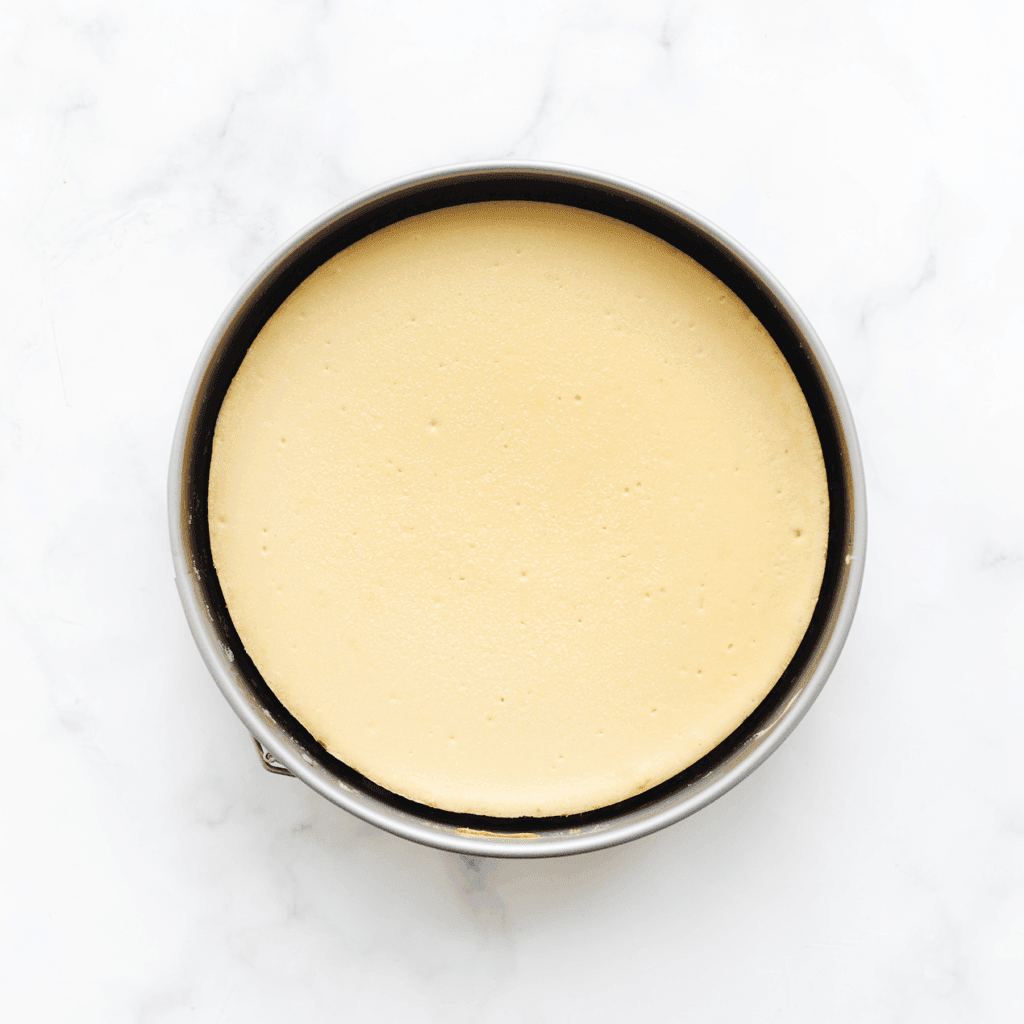 Zet de cheesecake in een voorverwarmde oven op 125 ℃. Bak het 75-80 minuten, of tot de zijkanten stevig zijn en het midden nog een beetje wiebelt. Schakel de oven uit en laat de cheesecake 1 uur in de oven liggen. Dit voorkomt dat de cheesecake inzakt of scheurt.