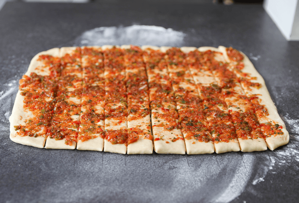 Snijd het deeg met een pizzasnijder of mes in 10 stroken.