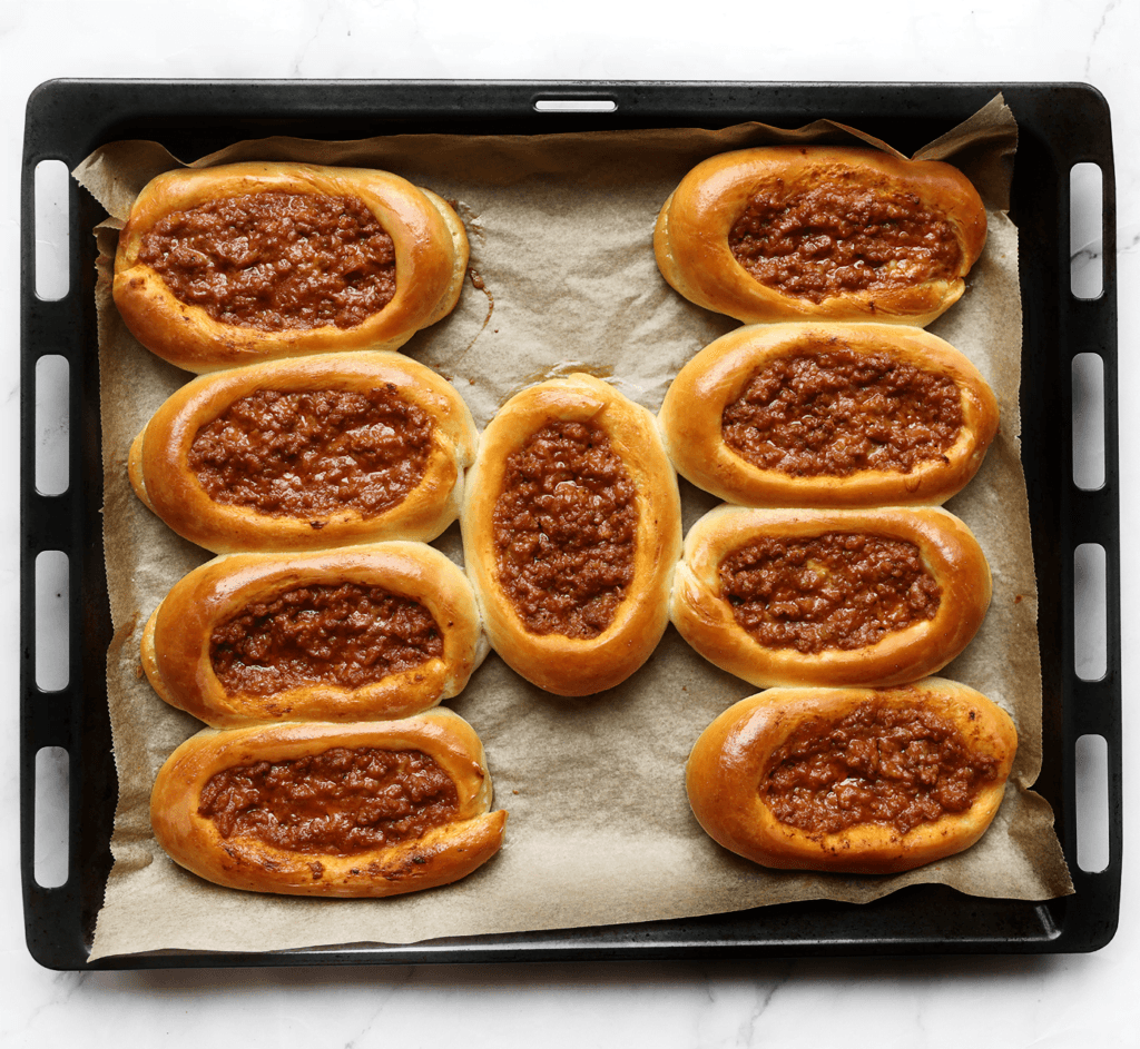 Zet de gehaktbroodjes in een voorverwarmde oven op 200 ℃. Bak ze 10-15 minuten of tot de broodjes mooi goudbruin zijn gekleurd. Houd de baktijd zelf in de gaten, want elke oven werkt anders. Dek de broodjes af met een schone theedoek zodra ze uit de oven komen, zo blijven ze heerlijk zacht.