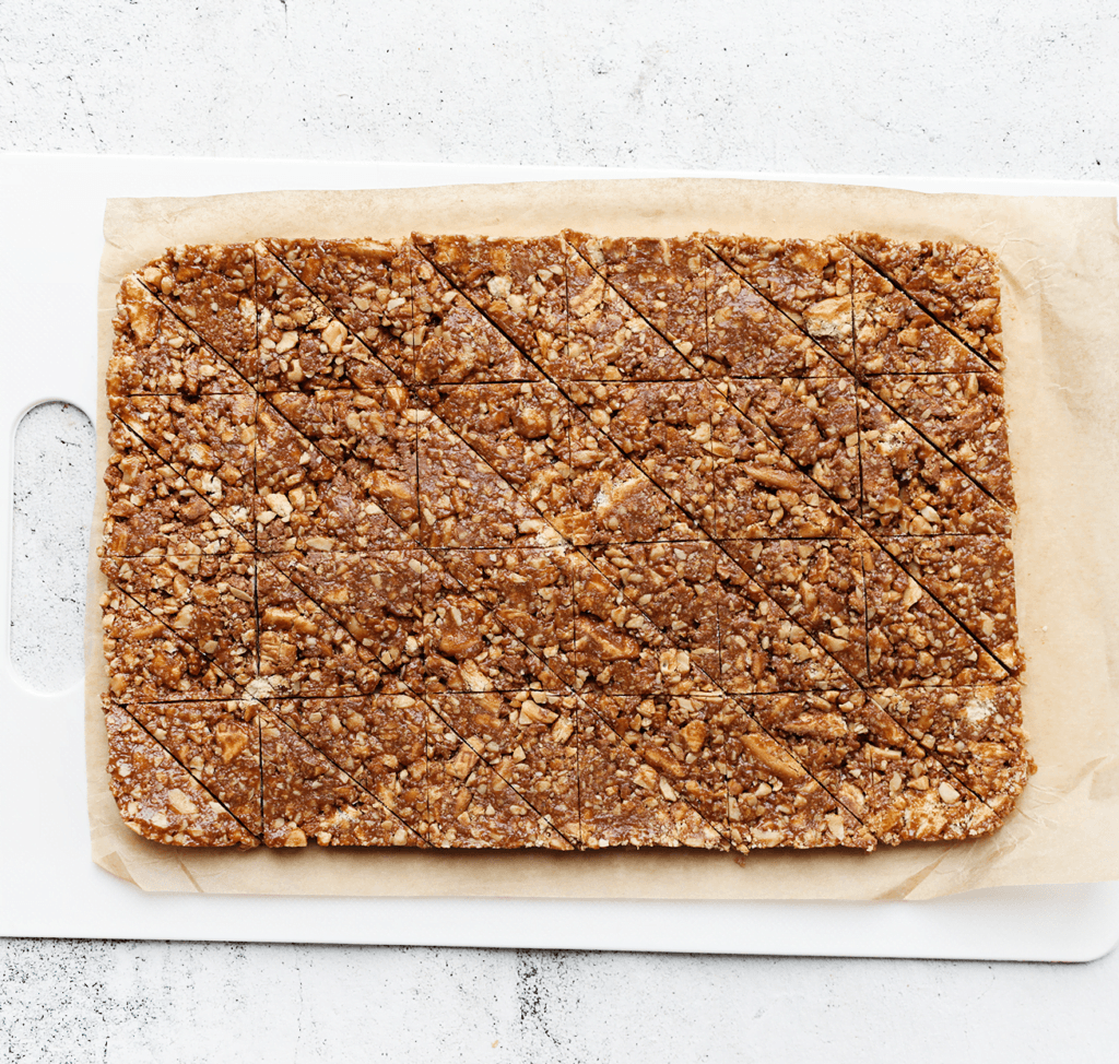 Haal het koekjesdeeg uit de springvorm/bakvorm en snijd het met een scherp mes in de gewenste stukken. Ik heb hier driehoekjes uit gehaald, maar je kunt ook voor ruitjes of blokjes gaan. Leg de koekjes weer in de vriezer zodat ze goed koud worden.