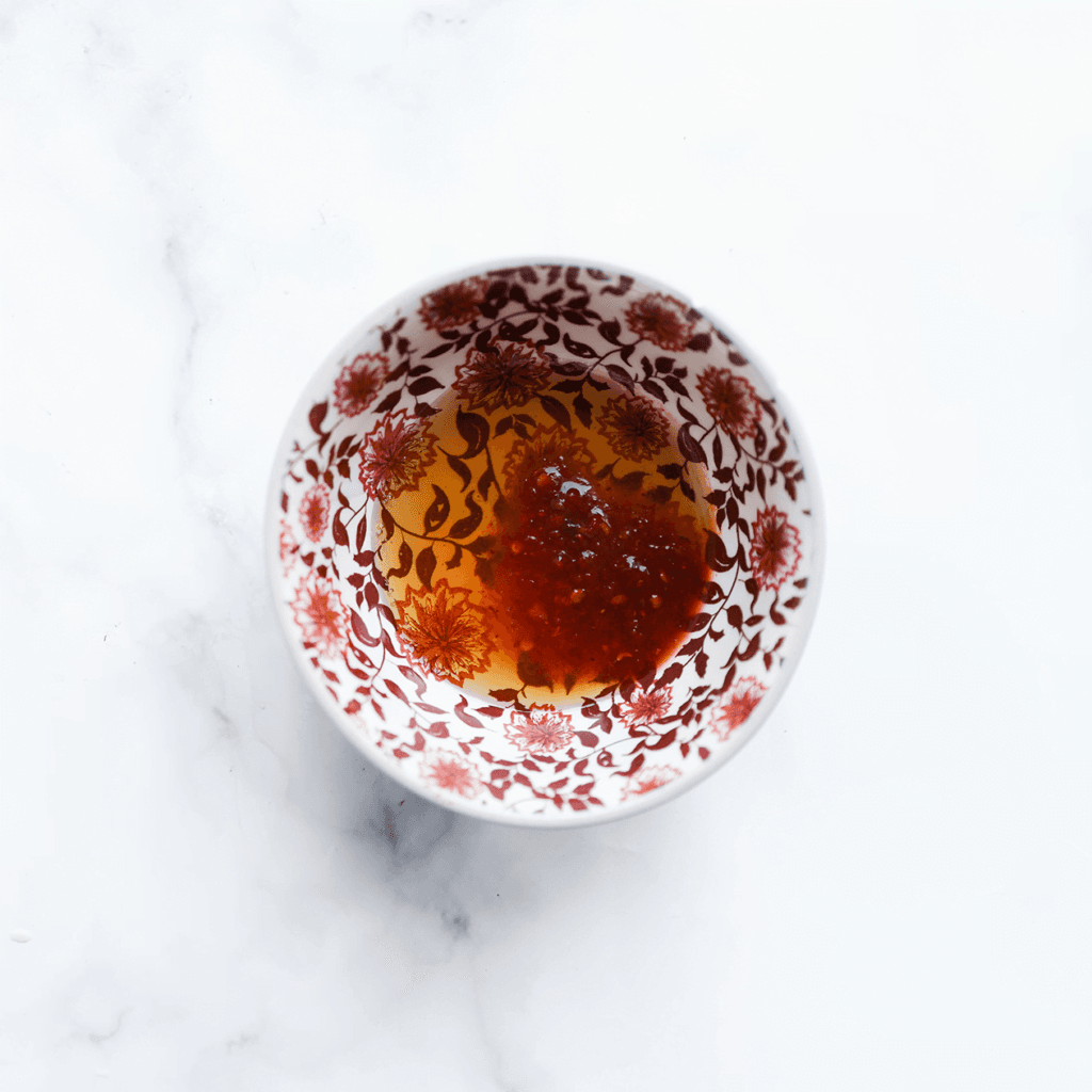 Doe de honing en sambal in een kom. Meng goed.