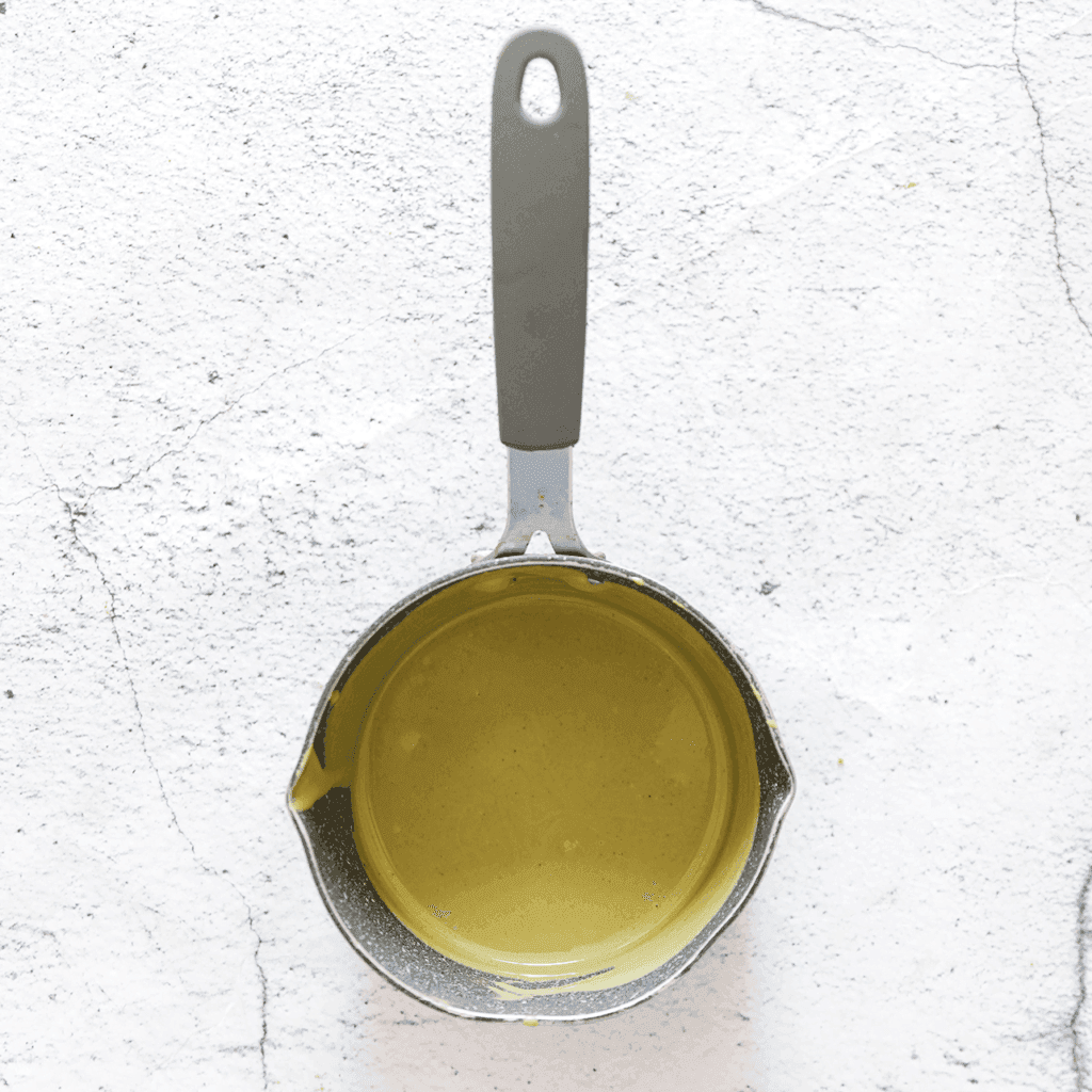 Smelt de pistachepasta in een steelpan op laag vuur.