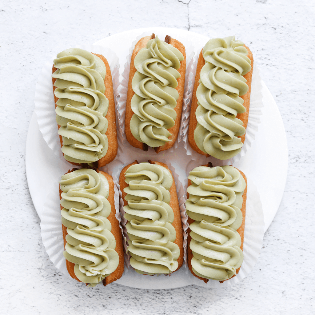 Spuit wat meer pistacheroom bovenop de bovenste magdalena en garneer met frambozen voor extra smaak en decoratie. Nu zijn je gevulde magdalena's klaar om van te genieten! De pistacheroom zal een heerlijke smaak en textuur toevoegen aan de magdalena's.