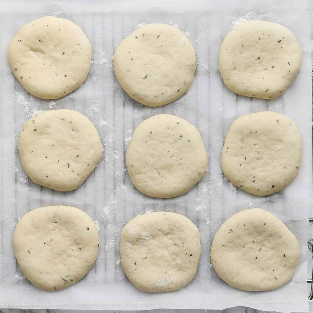 Leg het deeg op een rooster met bakpapier en laat 30 minuten rijzen of tot het deeg in omvang is verdubbeld.