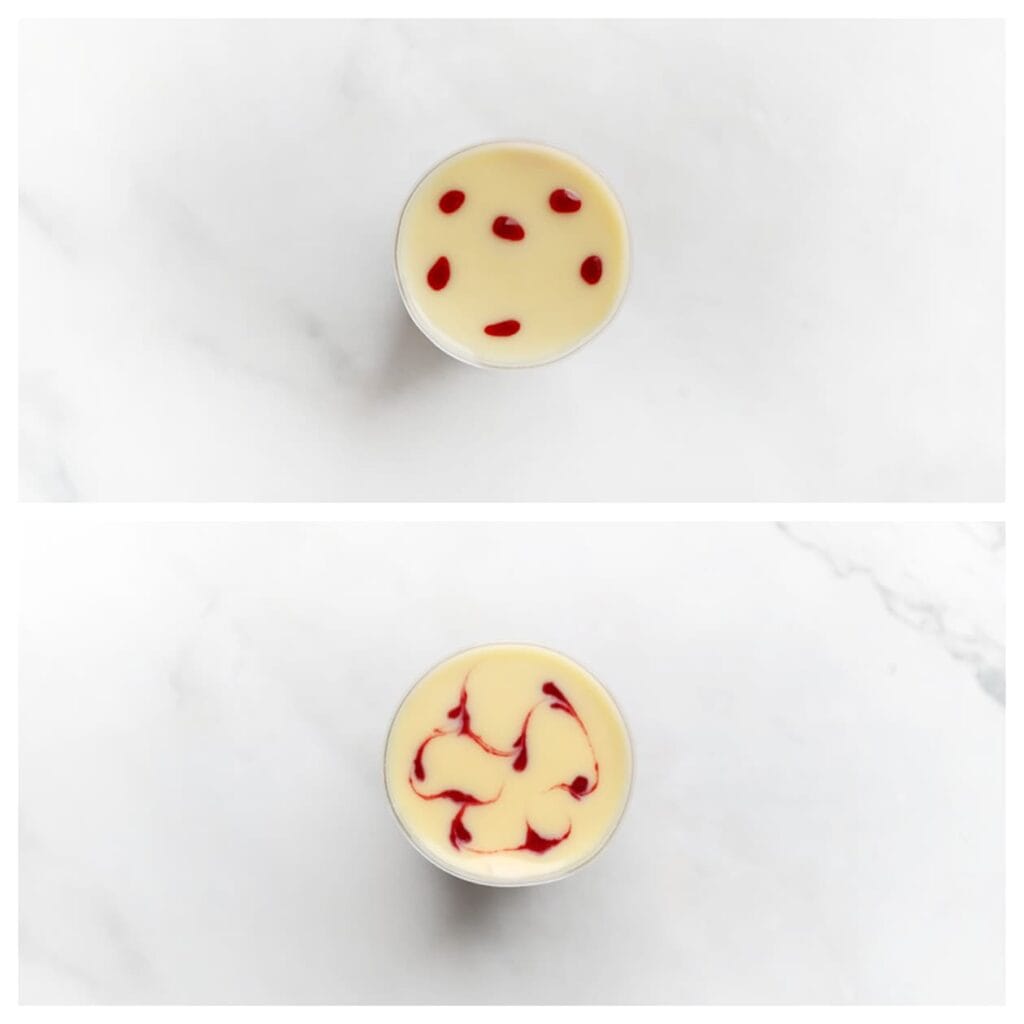 Spuit wat stipjes van het frambozenmengsel op de witte chocolade ganache en gebruik vervolgens een tandenstoker om een sierlijk patroon te creëren.