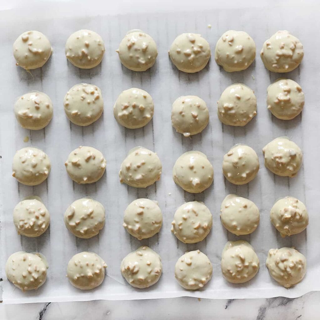 Leg de pindakoekjes op een vel bakpapier en laat de chocolade stevig worden.