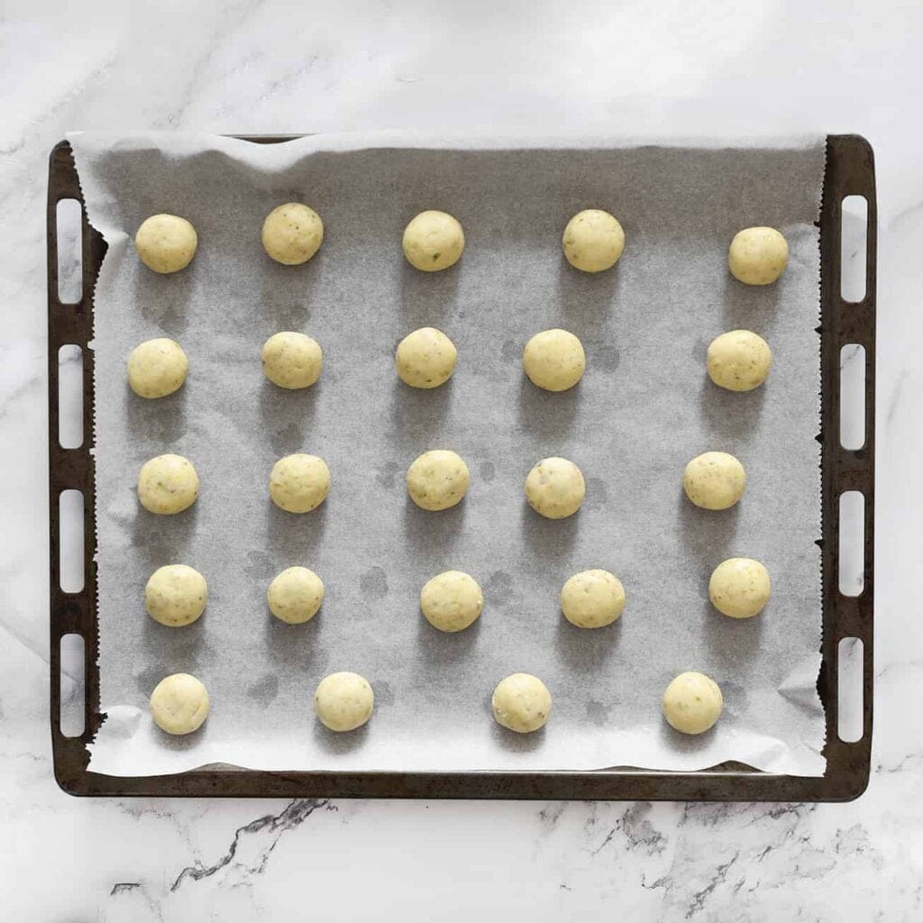 Plaats de maïzena-pistachekoekjes op een bakplaat bekleed met bakpapier.