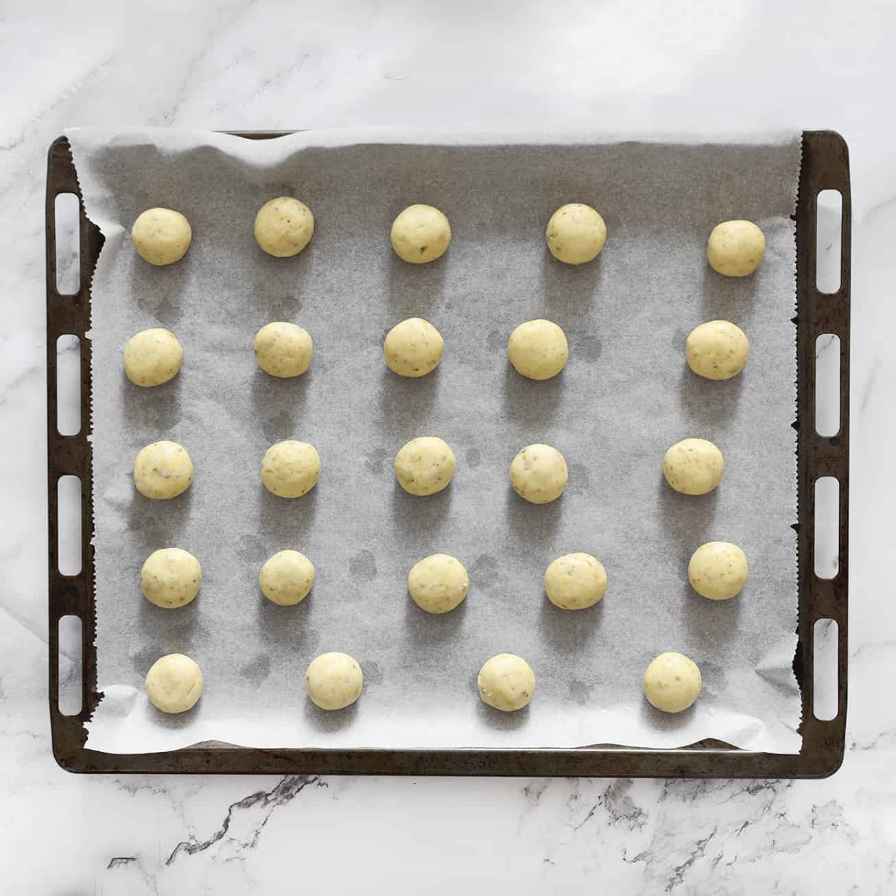 Pistachebollen leggen op een bakplaat met een vel bakpapier