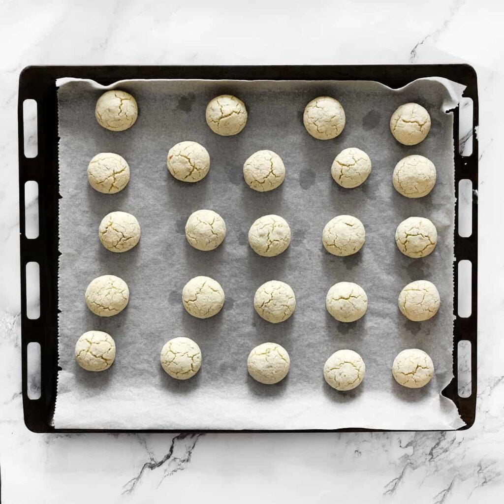 Plaats de maïzena-pistachekoekjes in een voorverwarmde oven op 190 ℃ en bak ze 10-15 minuten. Houd de baktijd goed in de gaten, aangezien elke oven anders kan zijn. Laat de koekjes vervolgens volledig afkoelen.