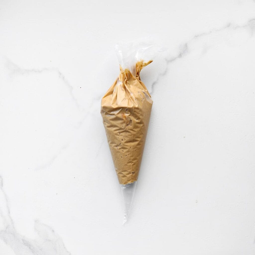 Doe het chocolade-koekmengsel in een spuitzak.