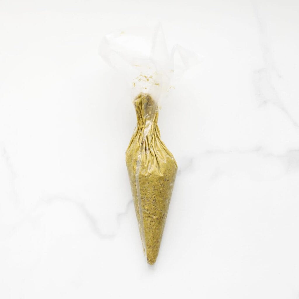 Doe de pistachepasta in een spuitzak.