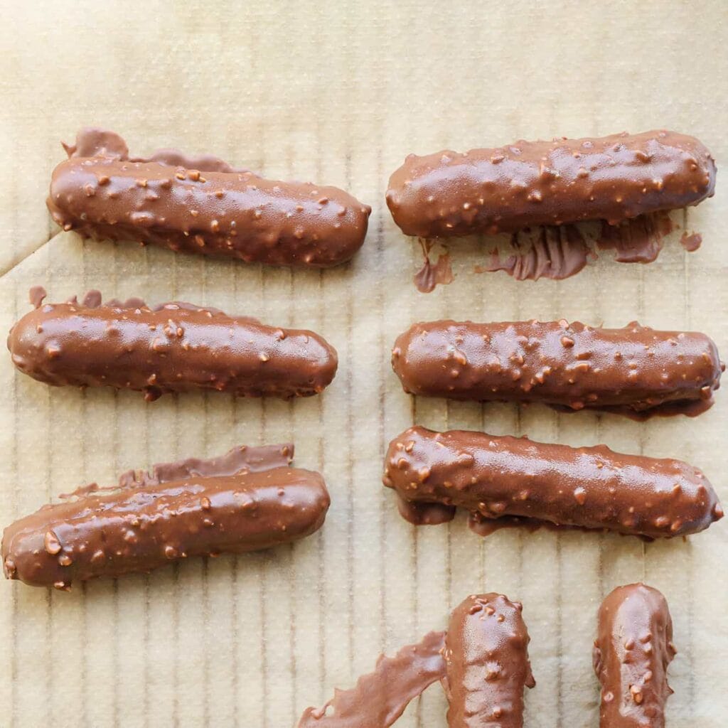 Leg de pinda-chocolade cheesecakes op een vel bakpapier en laat de chocolade stevig worden.