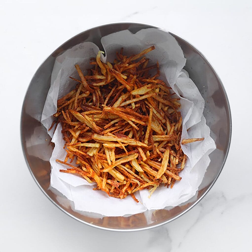 Verhit een laagje zonnebloemolie in een koekenpan of gebruik een friteuse (175 °C). Bak de frietjes goudbruin; dit gaat snel, dus houd ze goed in de gaten. Laat uitlekken op keukenpapier.