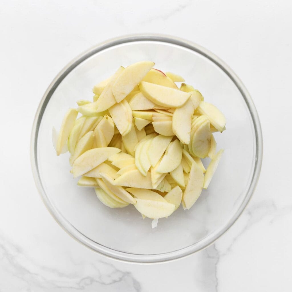 Schil de appels, verwijder het klokhuis, snijd ze in plakjes en doe ze in een diepe kom.