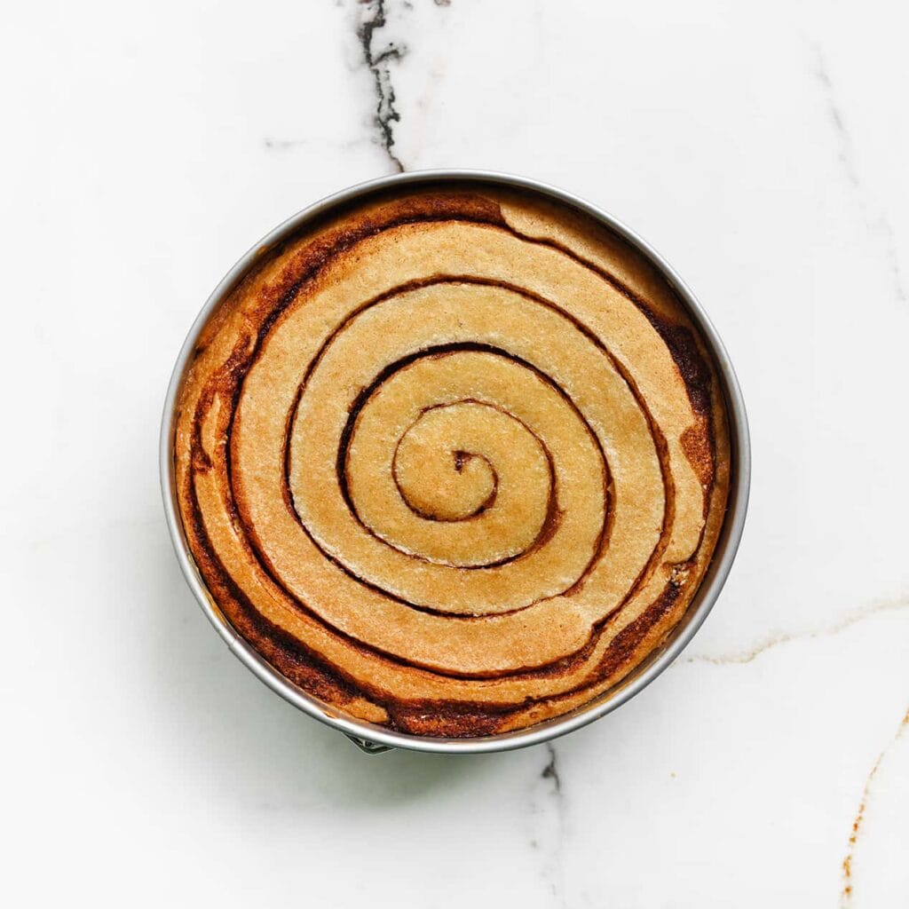 Zet de cinnamoncheesecake in een voorverwarmde oven op 150 ℃. Bak 60-65 minuten of tot de zijkanten stevig. Schakel de oven uit en laat de cinnamoncheesecake 1 uur in de oven liggen. Dit voorkomt dat de cheesecake inzakt/scheurt. Bewaar de afgekoelde cheesecake, afgedekt, in de koelkast. Het liefst een nachtje.