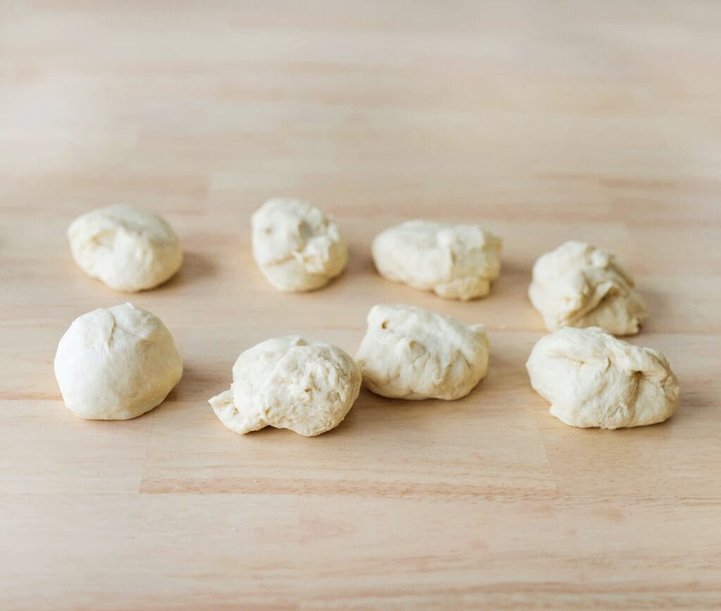 Verdeel het gerezen deeg in 8 gelijke stukken van ongeveer 75 g per stuk.