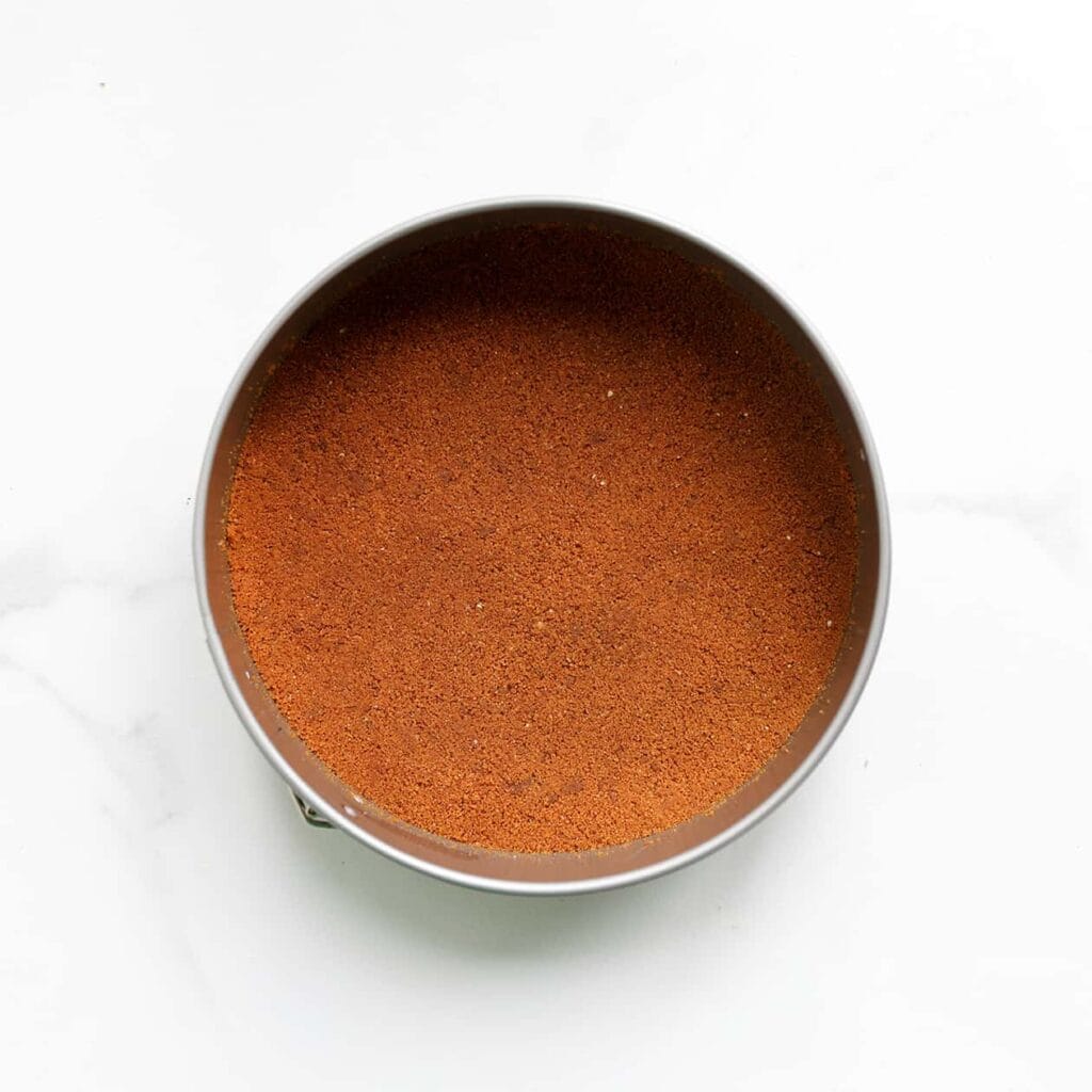 Druk het koekjesdeeg stevig op de bodem van een bakvorm (gebruik de achterkant van een lepel). Zet in de koelkast.