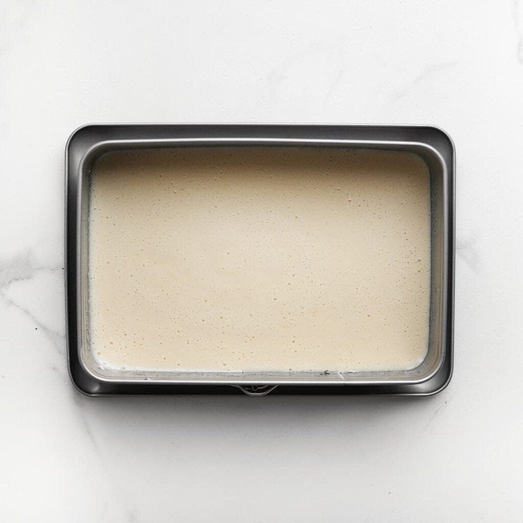 Giet het beslag in een ingevette springvorm en bekleed de bodem met bakpapier. Bak de cake in een voorverwarmde oven op 160 ℃ voor 12-18 minuten, of totdat de cake gaar is (de cake is gaar wanneer een satéprikker er droog uitkomt). Let goed op de baktijd, want elke oven is anders. Laat de cake 10-15 minuten afkoelen.