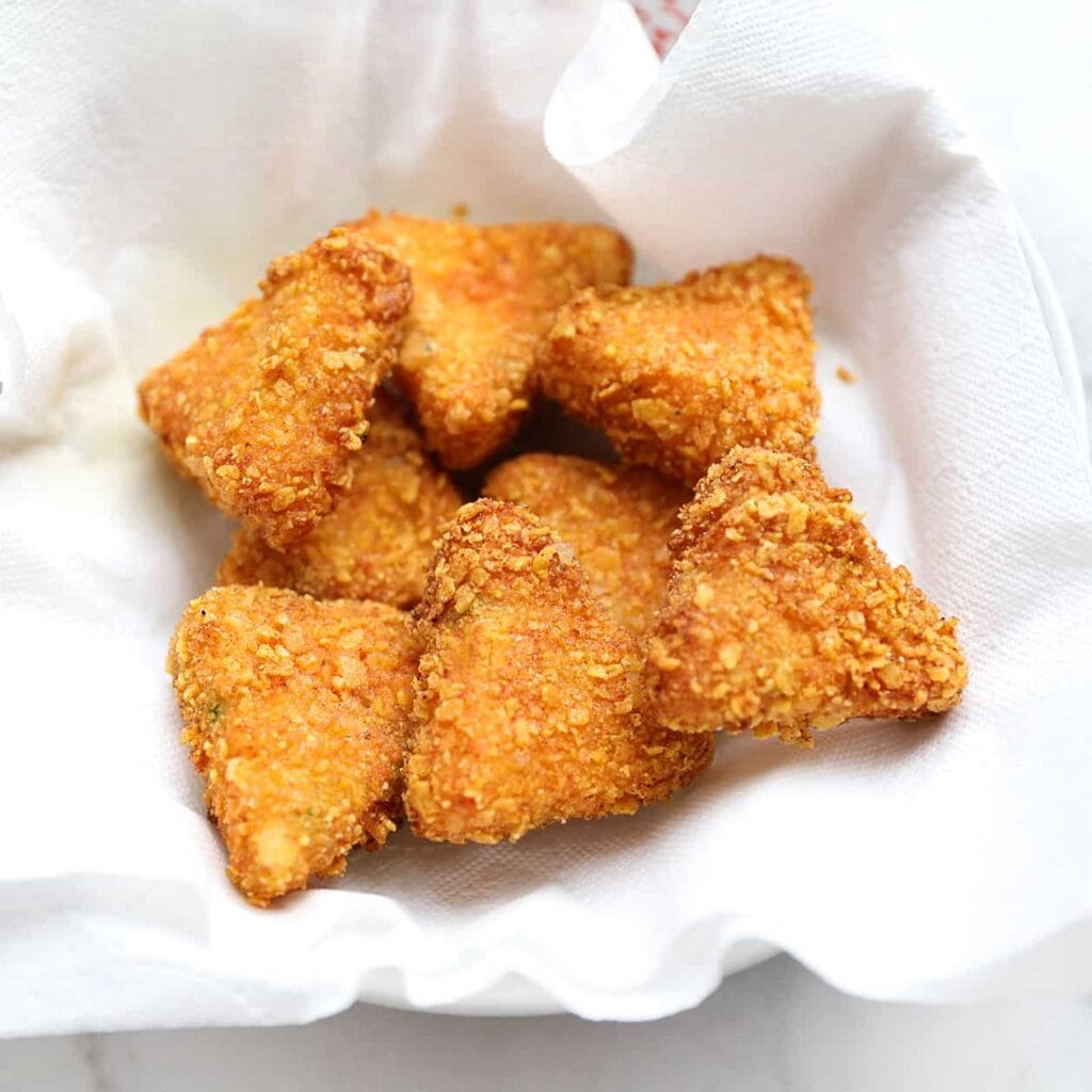 Verhit een laagje zonnebloemolie in een koekenpan op middelhoog vuur, of gebruik een friteuse (175°C). Bak de nachos bites goudbruin en knapperig. Laat uitlekken op keukenpapier.