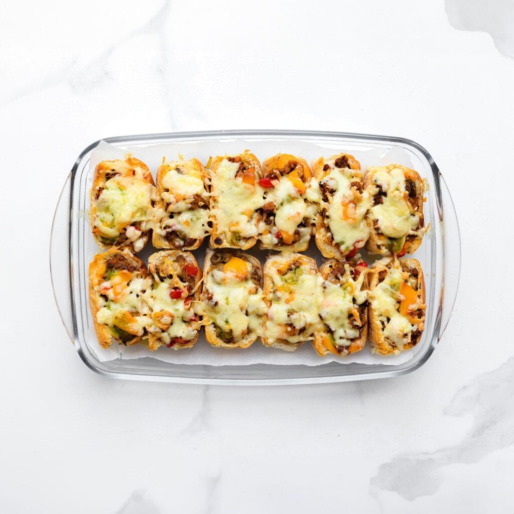 Zet de broodjes in een voorverwarmde oven op 200 °C. Bak 5-7 minuten, of totdat de kaas is gesmolten.