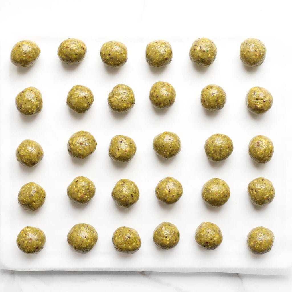 Leg de gevulde pistachebollen op een vel bakpapier en zet ze even in de vriezer om stevig te worden.