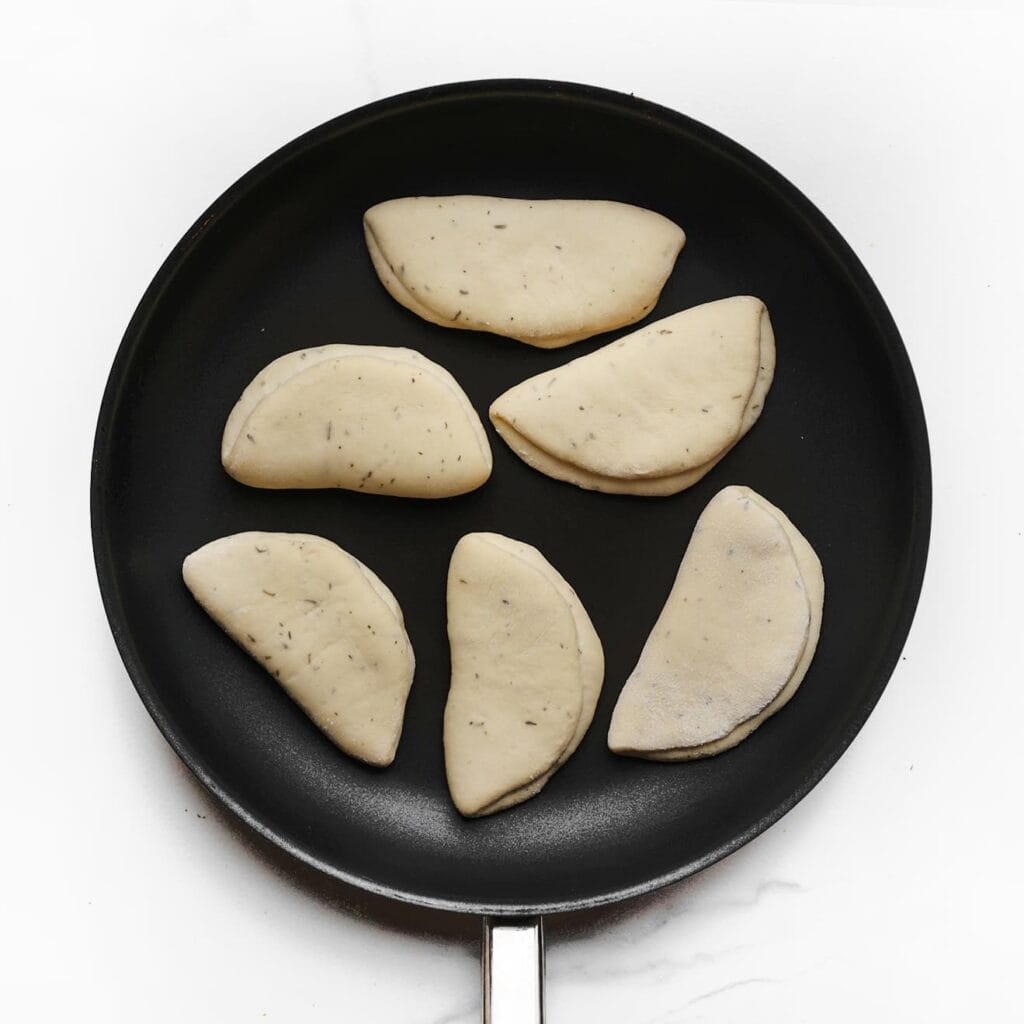 Verhit een koekenpan met een dikke bodem op middelhoog vuur. Bak de broodjes aan beide kanten goudbruin, enkele minuten per kant. Laat ze afkoelen op een rooster.