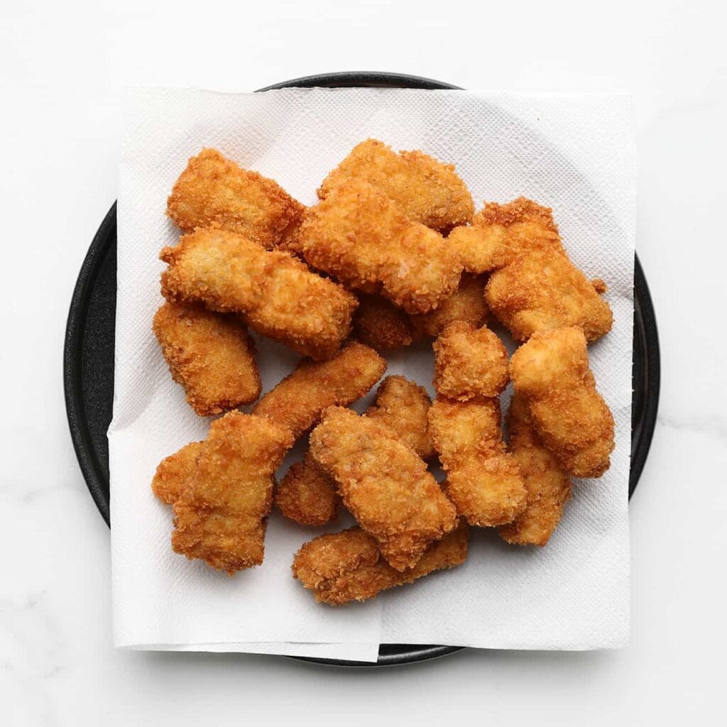 Verhit intussen een laagje zonnebloemolie in een koekenpan op middelhoog vuur (175 ℃) of gebruik een friteuse. Bak de kabeljauwstukken goudbruin en krokant.