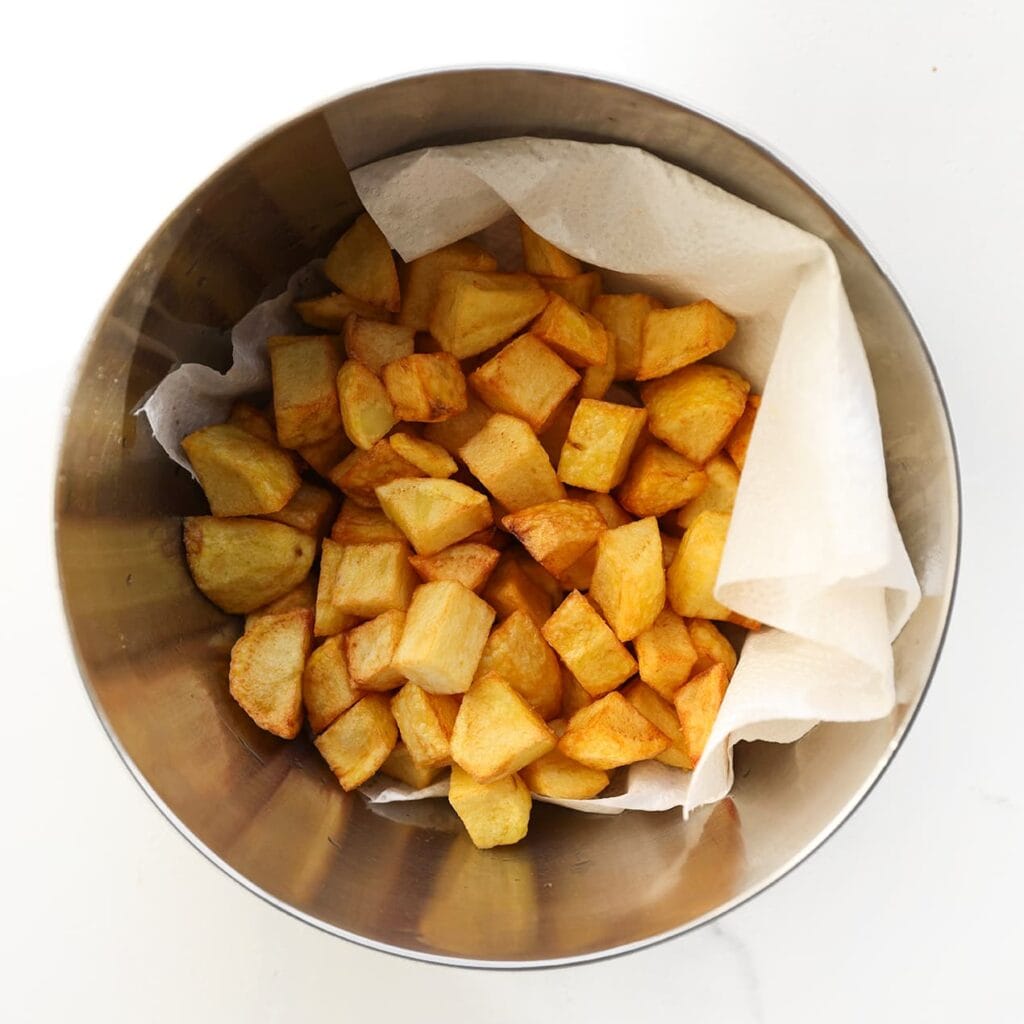 Verhit de olie in een koekenpan of friteuse tot 175 °C en bak de aardappelblokjes in 5-7 minuten goudbruin, afhankelijk van de gewenste knapperigheid. Laat uitlekken op keukenpapier.