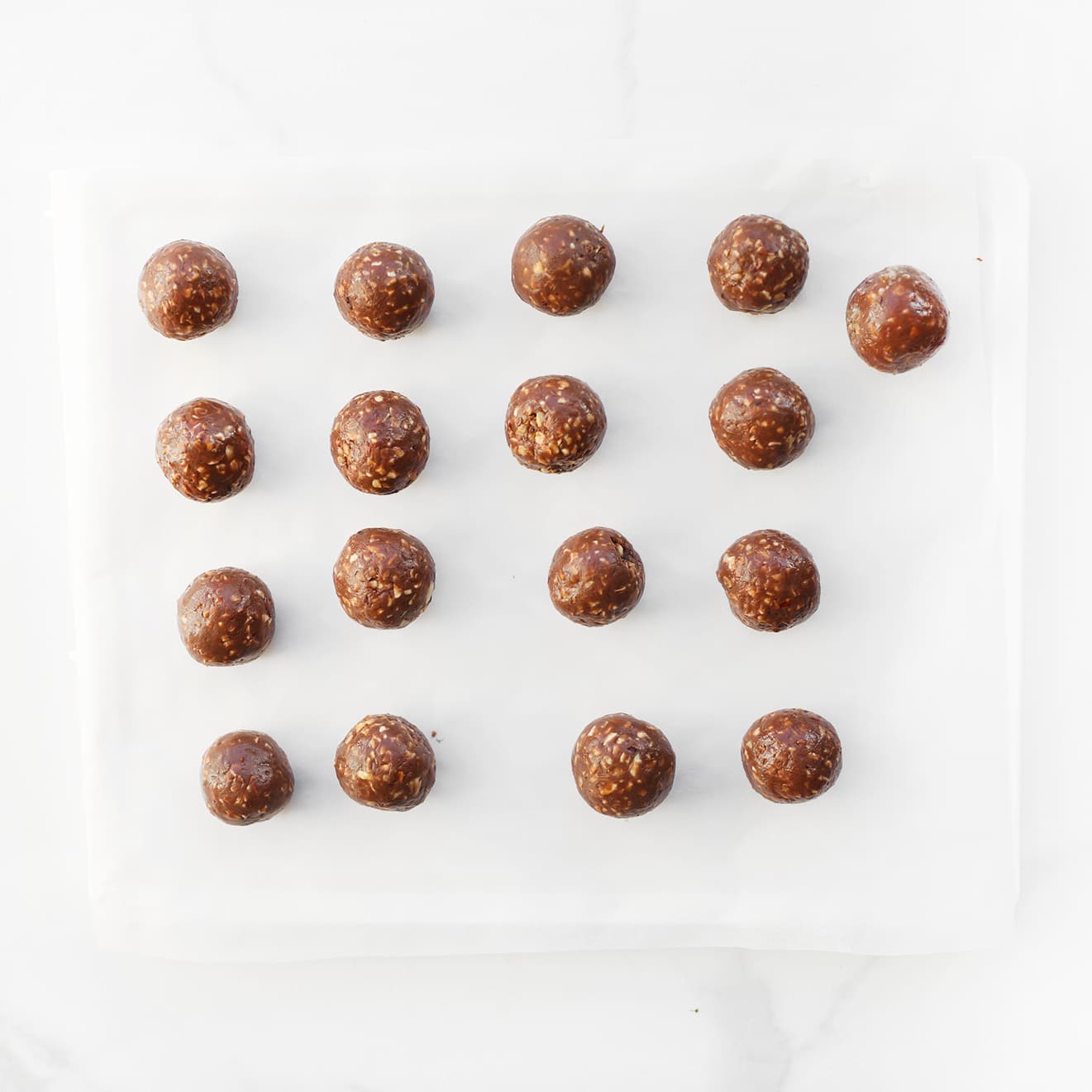 Chocolade-hazelnootbollen op een vel bakpapier leggen