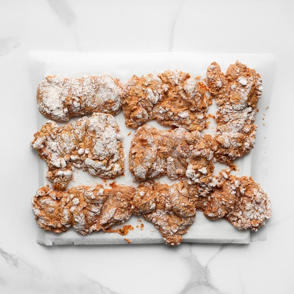 Leg de gepaneerde kip in de vriezer tot deze goed stevig is.