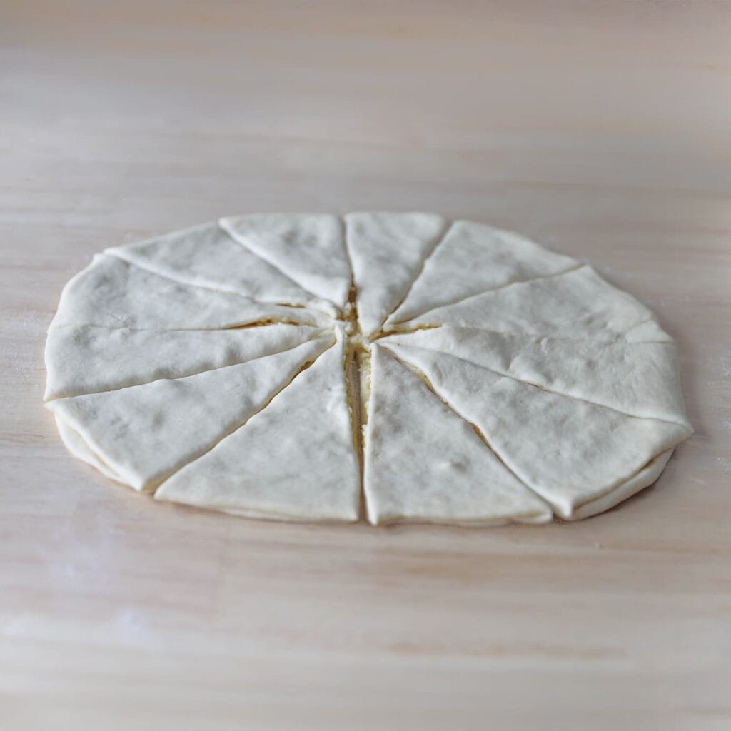 Snijd het deeg met een pizzasnijder in 12 gelijke puntjes.