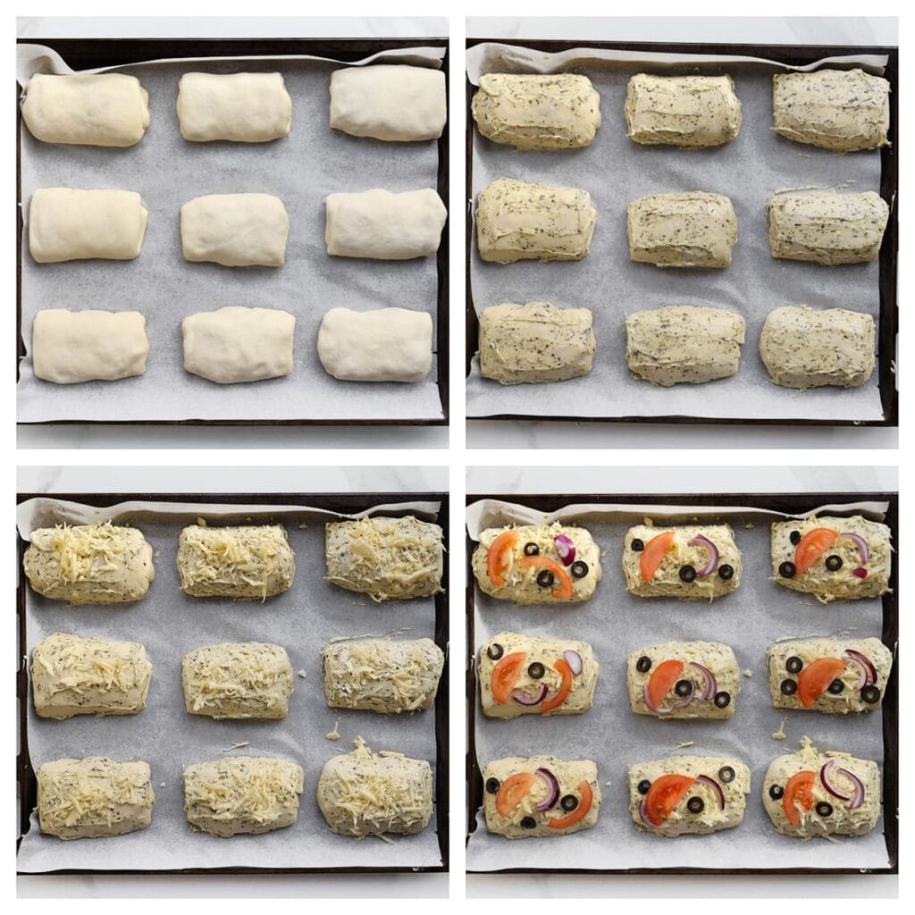 Plaats de gevulde broodjes op een bakplaat met bakpapier. Smeer de bovenkant in met kruidenboter en garneer met geraspte kaas, zwarte olijven, tomaat en rode ui.